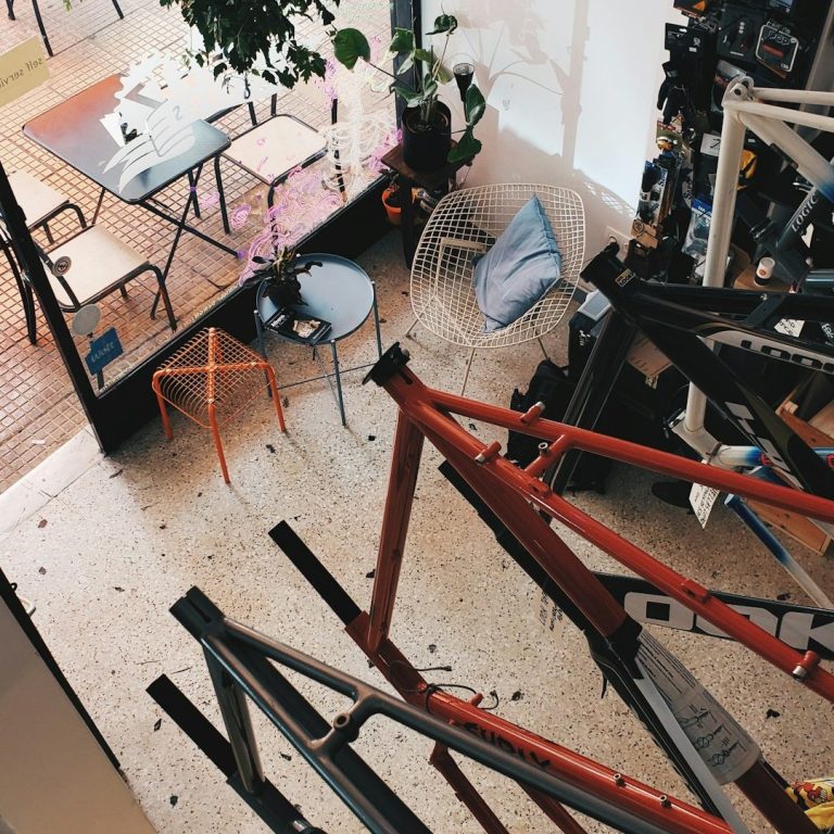 Blick auf einen Atelierraum mit Fahrradrahmen und einem Tisch im Freien.